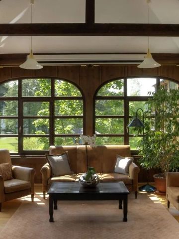 Gemütliche Lounge mit großen Fenstern und bequemen Sesseln im Hotel Schloss Elmau.