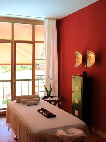 Wellnessraum mit Massagetisch und rötlichen Wänden im Hotel