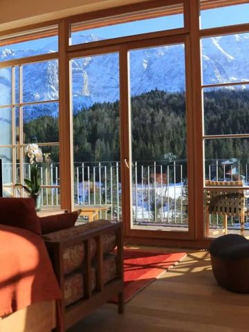 Zimmeransicht mit Panoramafenstern und Blick auf verschneite Berge