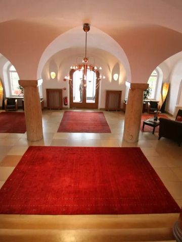 Großzügiger Eingangsbereich mit rotem Teppich und eleganter Beleuchtung im Schloss Elmau.