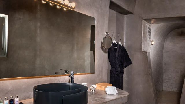 Andronis Luxury Suites Bad im dunkelen Flair mit Bademantel, großem Spiegel und Annehmlichkeiten